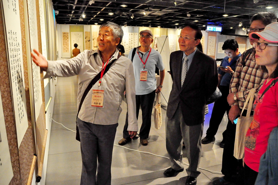 雲南省姚安縣書法家協會主席趙獻銓（左，趙鶴清後人）現場作品導覽賞析。